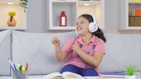 Girl-child-listening-to-music-with-headphones-at-home